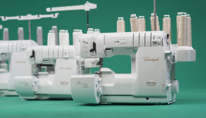 Three Triumph sewing machines on a blue/green background.