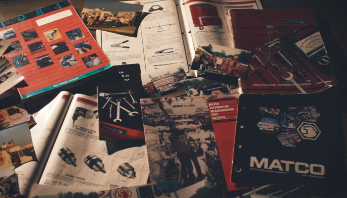A table covered in Matco tools magazines and catalogs.